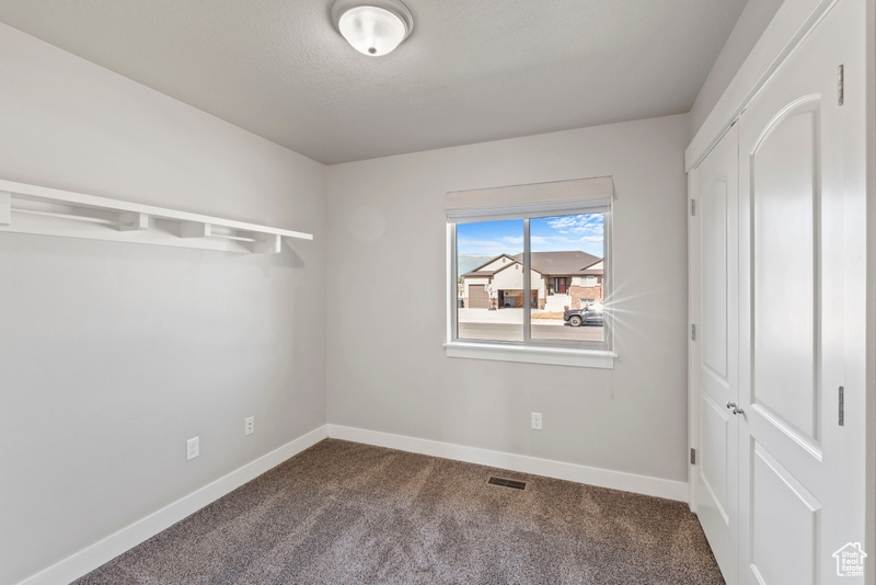 Unfurnished bedroom with carpet flooring and baseboards