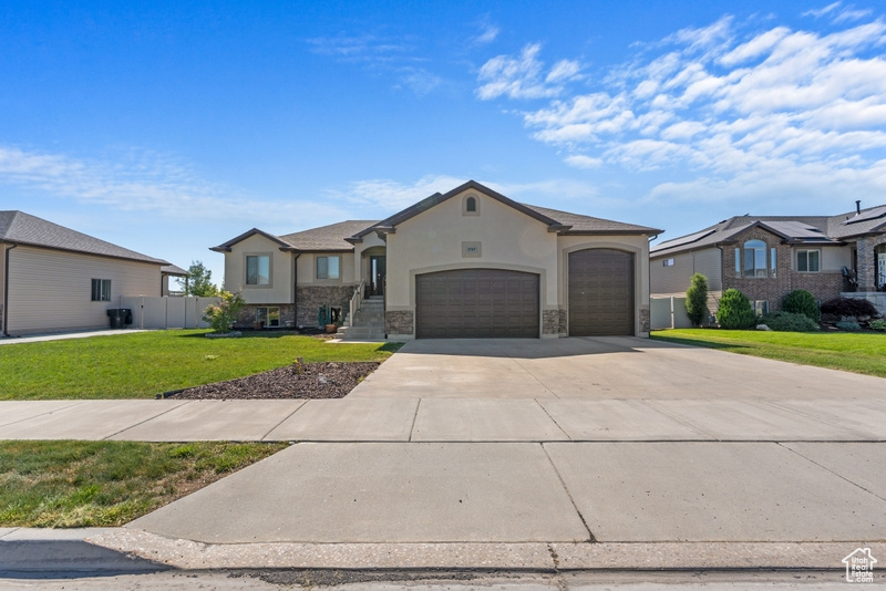 French country style house featuring stucco siding, a garage, driveway, and stone siding