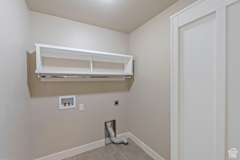 Laundry room with hookup for an electric dryer, washer hookup, and a textured ceiling