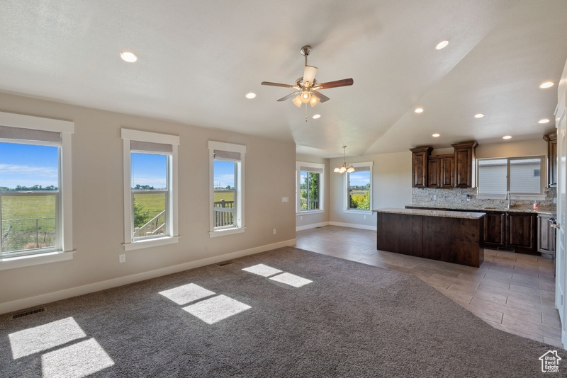 Kitchen with a center island, healthy amount of natural light, dark brown cabinetry, recessed lighting, and decorative backsplash