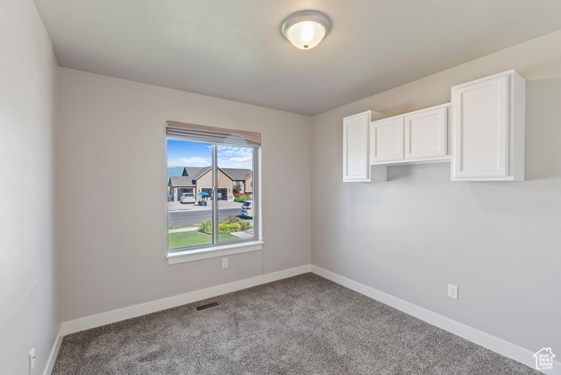 Empty room featuring baseboards and carpet floors