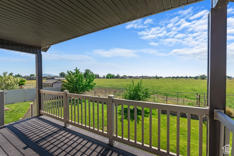 Wooden deck with a fenced backyard and a view of rural / pastoral area