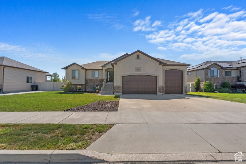 French country home featuring stucco siding, an attached garage, and concrete driveway