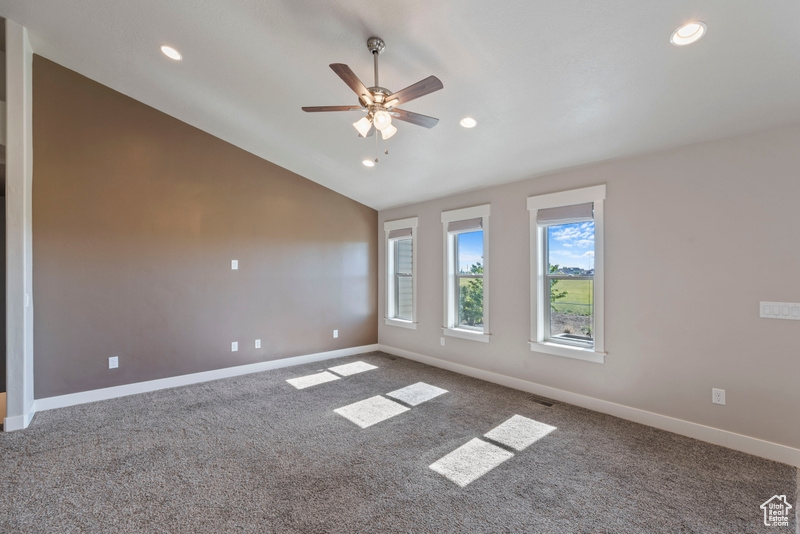 Carpeted spare room featuring recessed lighting, ceiling fan, and lofted ceiling