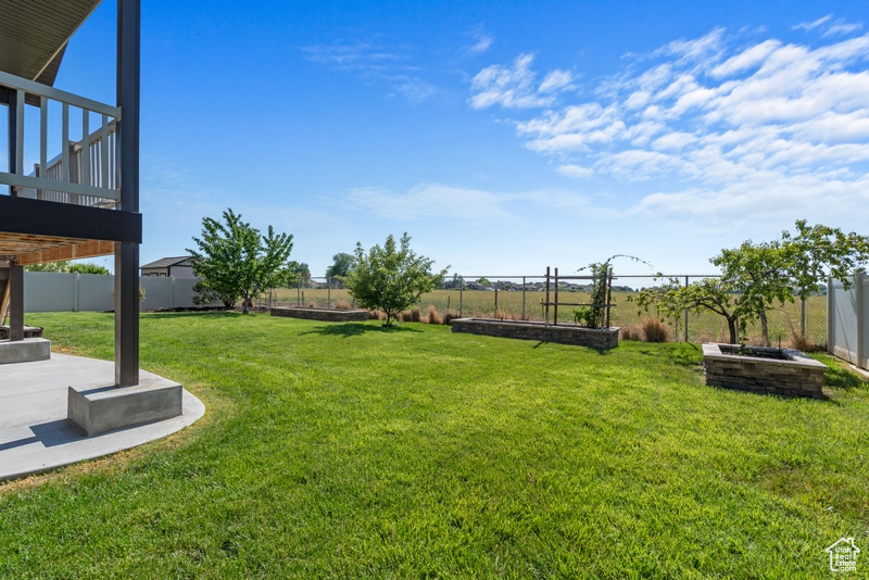 Fenced backyard with a patio area and a garden