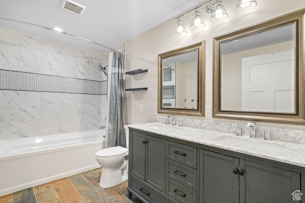 Bathroom featuring shower / bath combo and double vanity