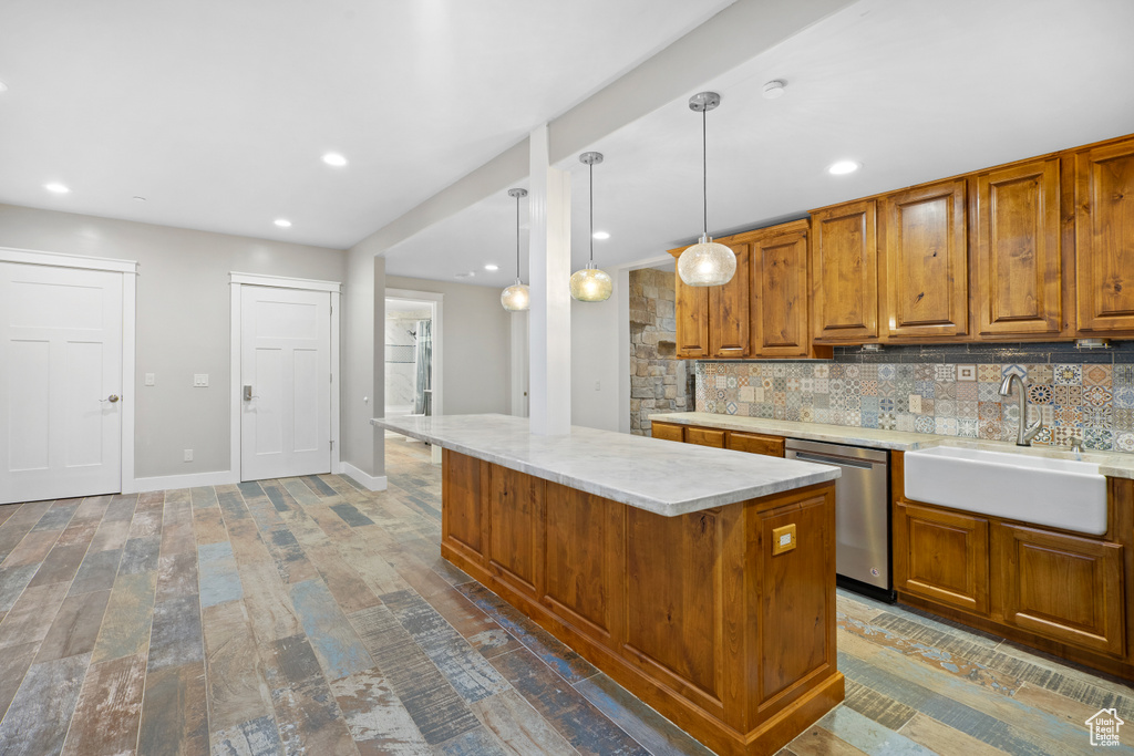 Kitchen with stainless steel dishwasher, brown cabinets, decorative backsplash, a center island, and decorative light fixtures