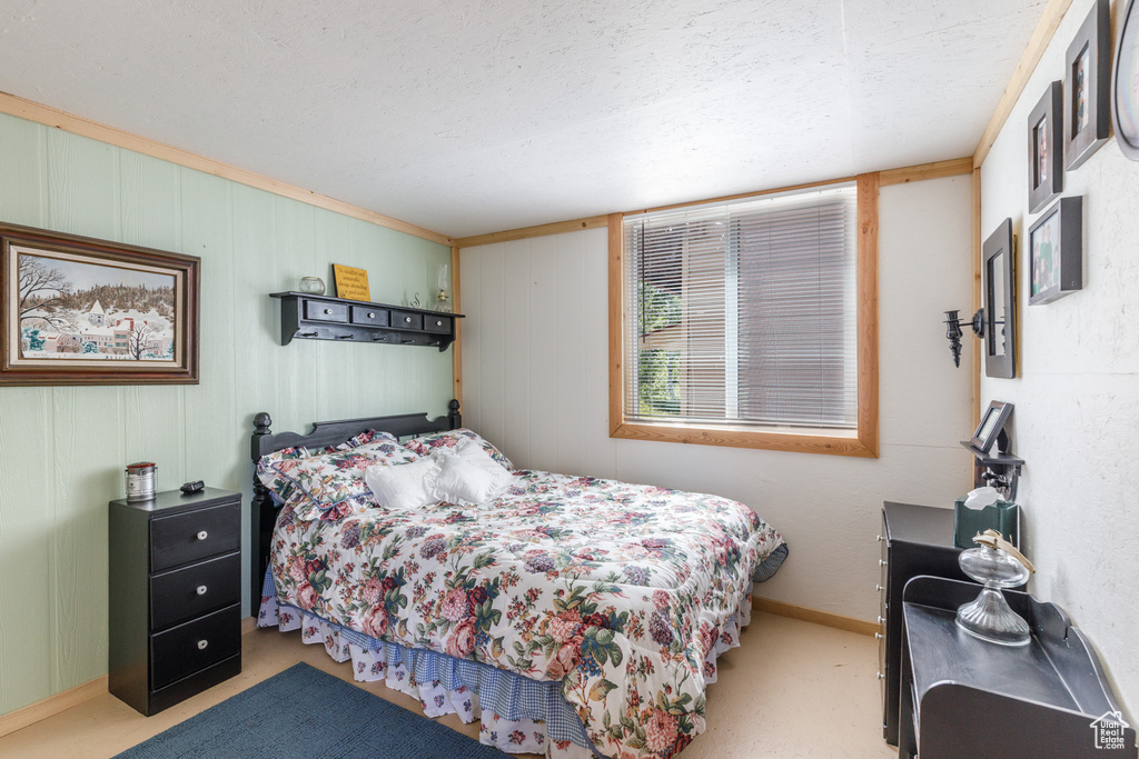 Carpeted bedroom featuring baseboards and a textured ceiling