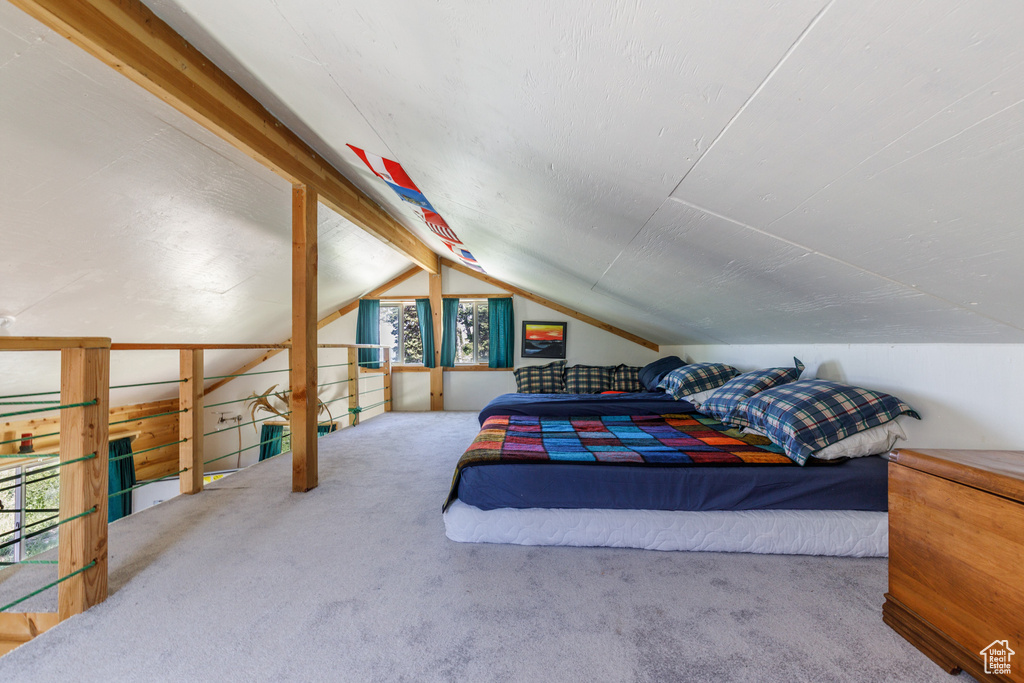 Bedroom with carpet floors and lofted ceiling