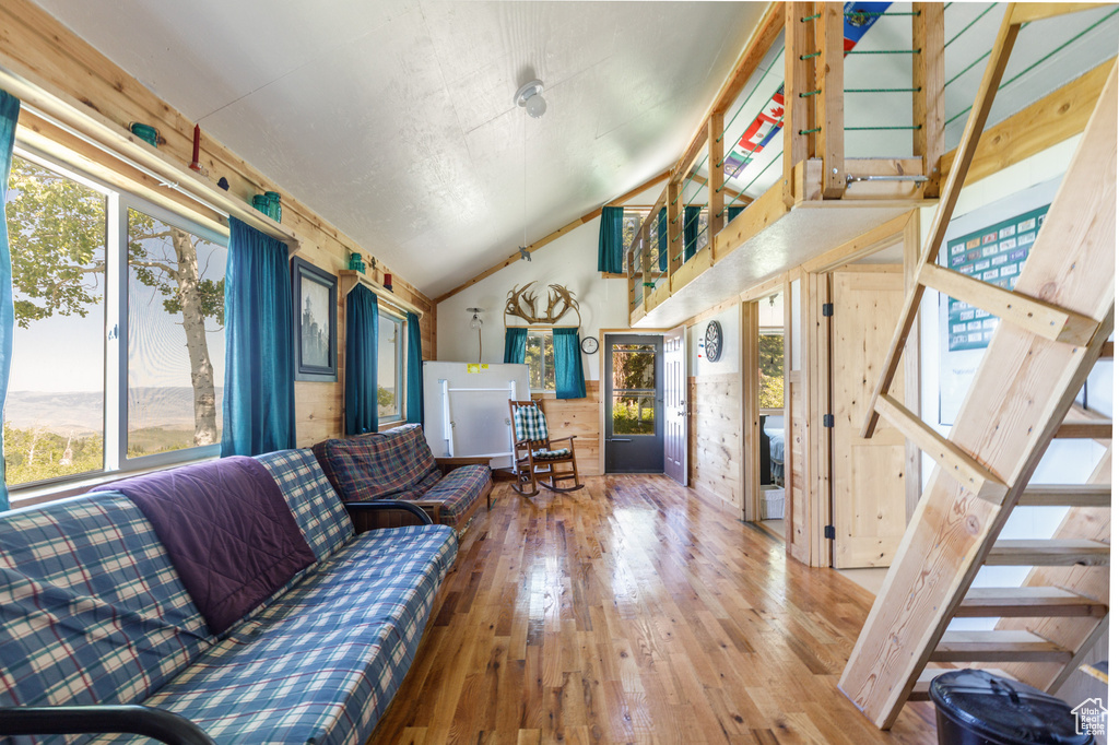 Living room featuring plenty of natural light, lofted ceiling, hardwood / wood-style floors, and stairway