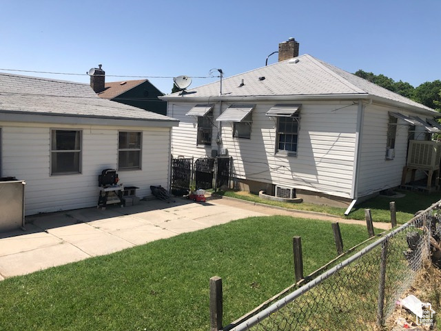 Back of property featuring a chimney and a patio area