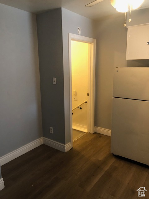 Empty room featuring dark wood-style flooring and ceiling fan