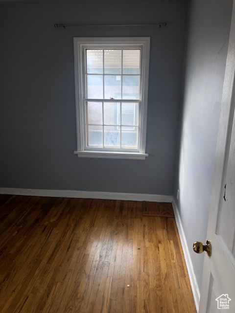 Spare room with hardwood / wood-style floors and baseboards
