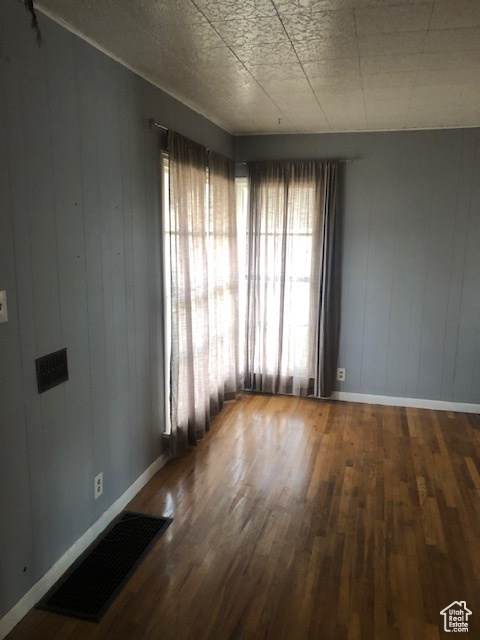 Unfurnished room featuring wood finished floors and baseboards