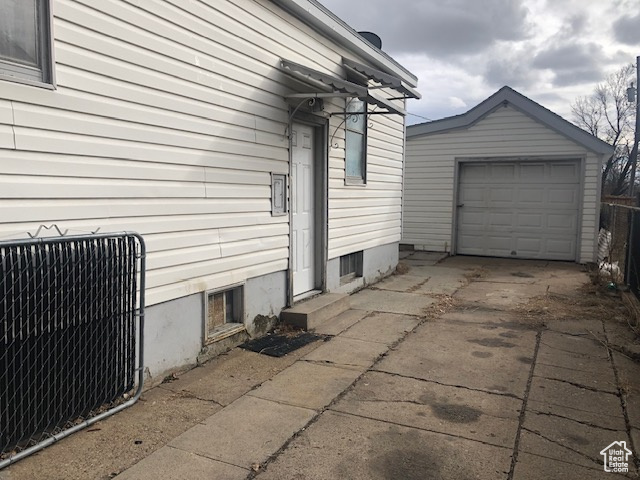 View of side of home with driveway, an outbuilding, and a garage