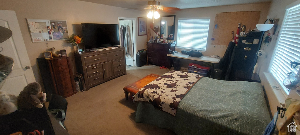 Bedroom with light carpet and a ceiling fan