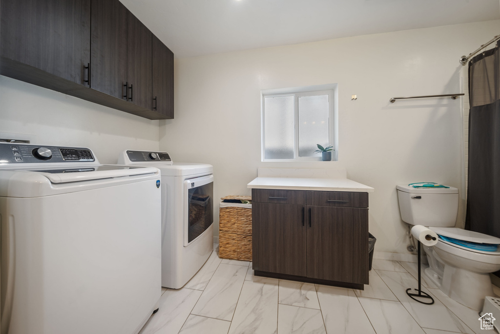 Laundry area featuring separate washer and dryer and light marble finish floors