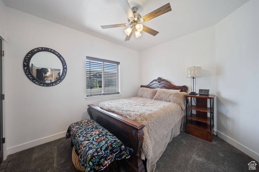 Carpeted bedroom with baseboards and a ceiling fan