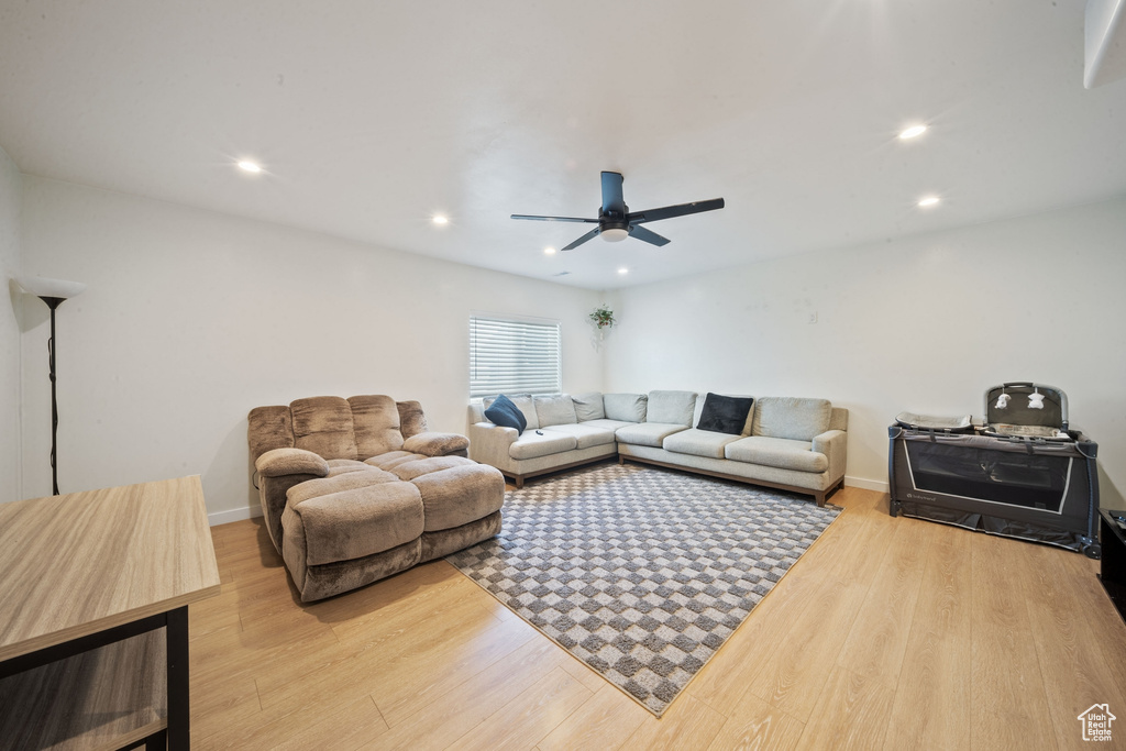 Living room with wood finished floors, ceiling fan, and recessed lighting
