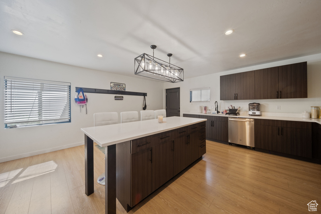 Kitchen featuring dishwasher, dark brown cabinets, light countertops, light wood finished floors, and recessed lighting