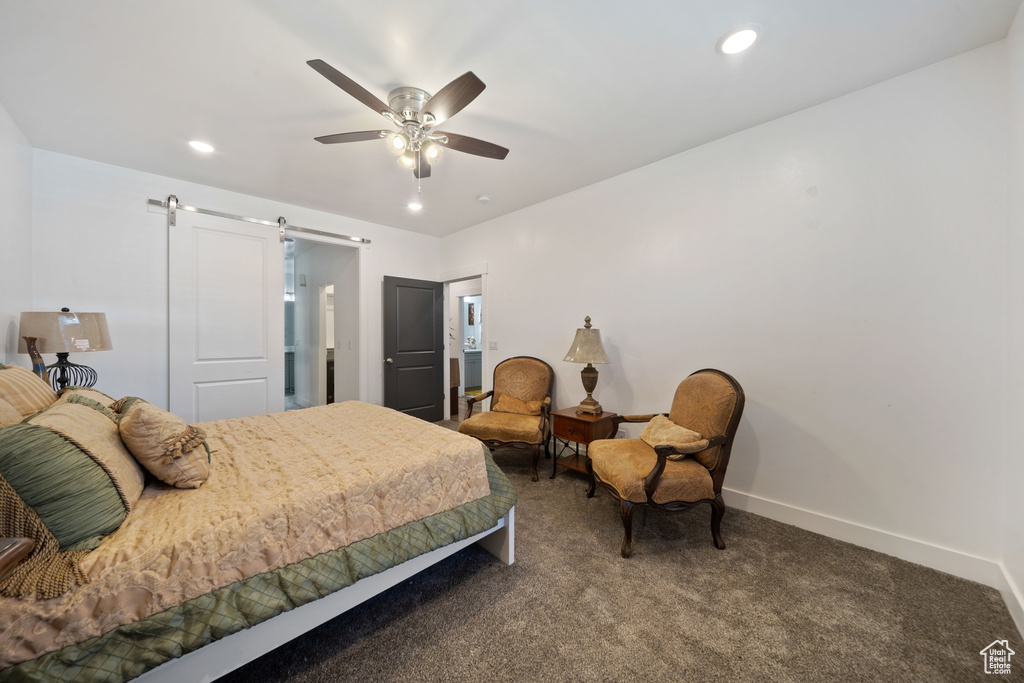 Carpeted bedroom with a barn door, a ceiling fan, and recessed lighting