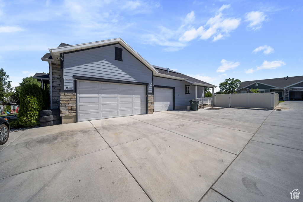 Ranch-style house featuring concrete driveway and an attached garage