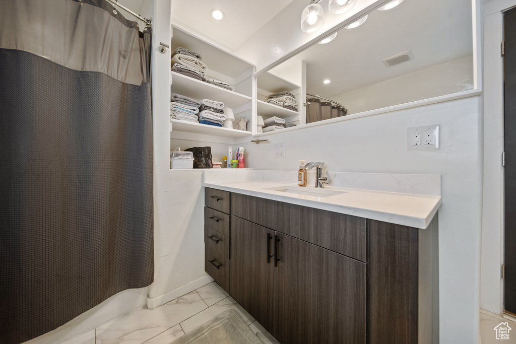 Bathroom with marble look tile flooring, vanity, a shower with curtain, and recessed lighting
