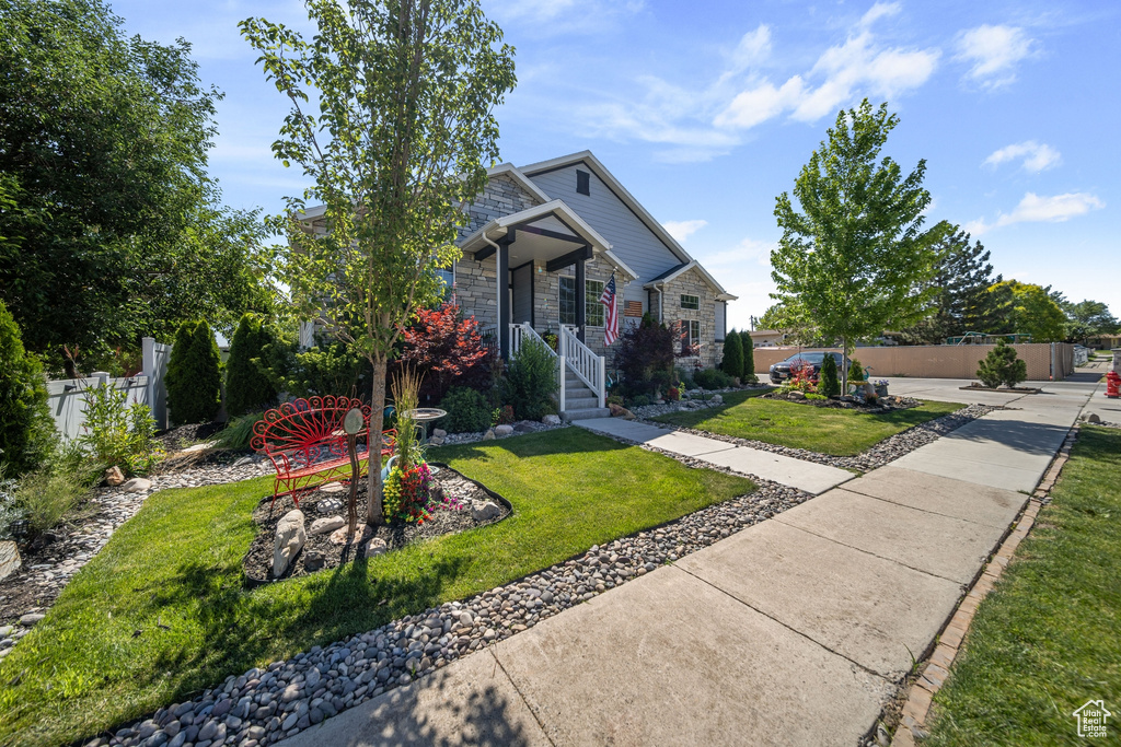 View of front of home with stone siding and covered porch