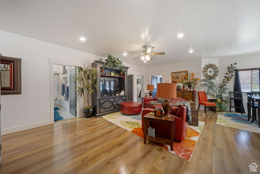 Living room with light wood finished floors, a ceiling fan, and recessed lighting