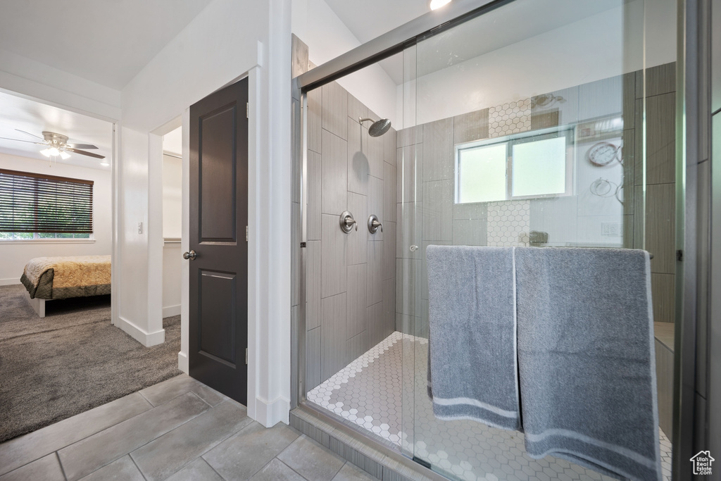 Bathroom with ensuite bath, tiled shower, and a ceiling fan