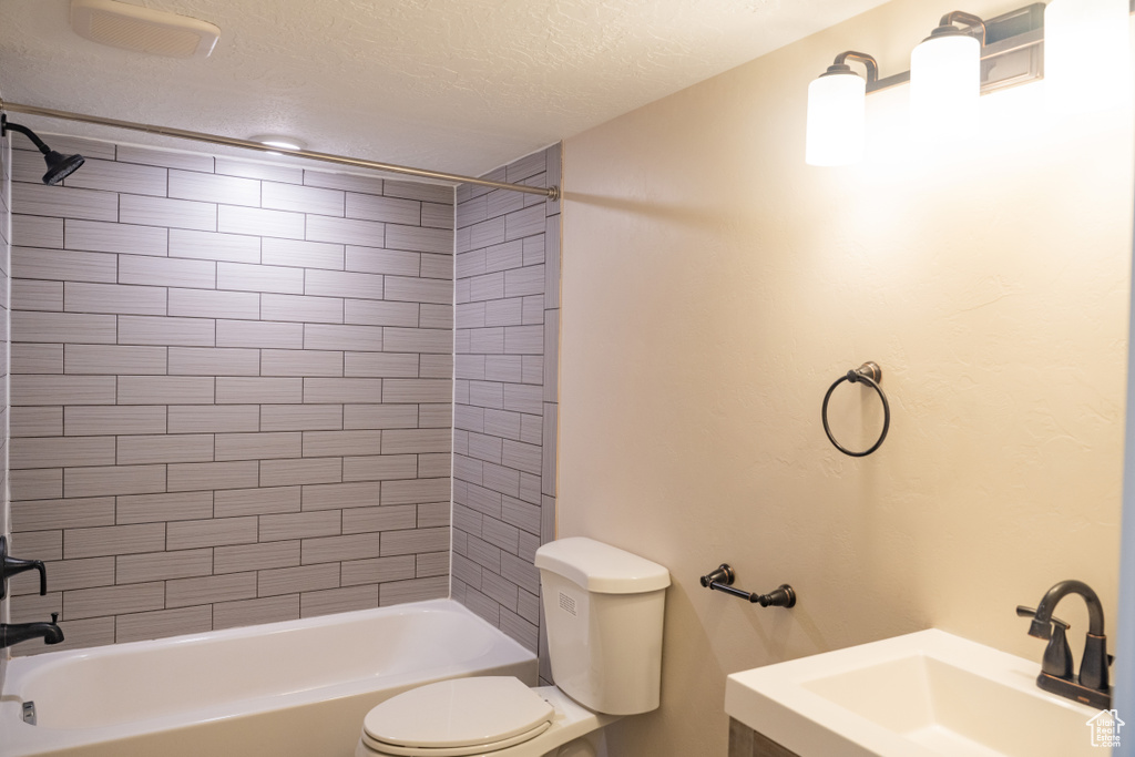 Full bath with  shower combination, a textured ceiling, and vanity