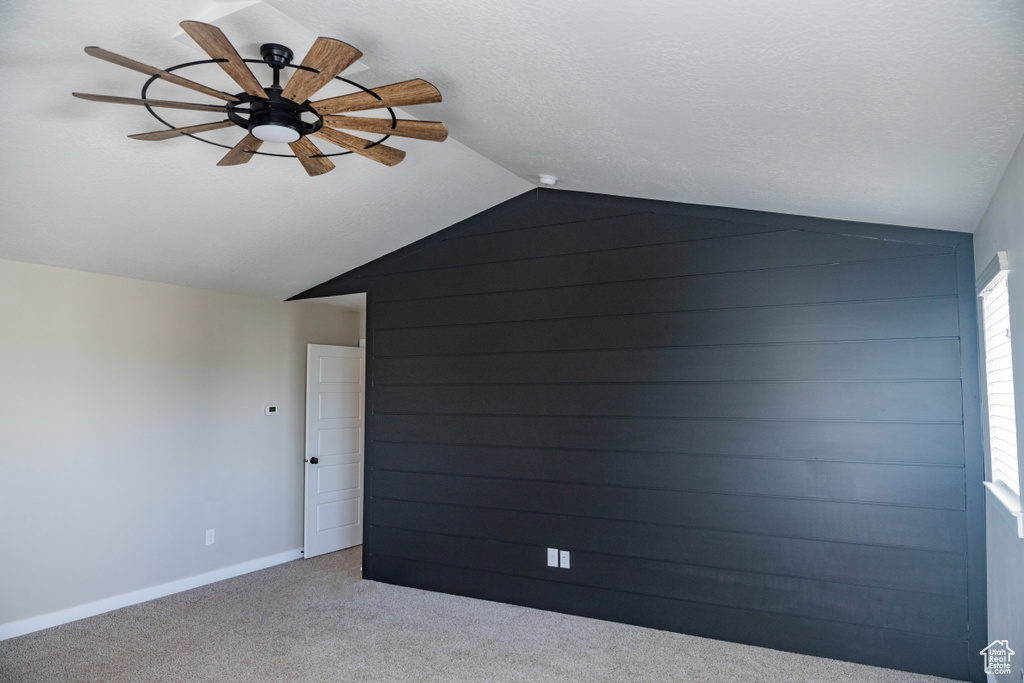 Bonus room with lofted ceiling, a ceiling fan, and carpet