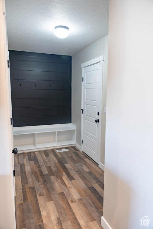 Mudroom with a textured ceiling and wood finished floors