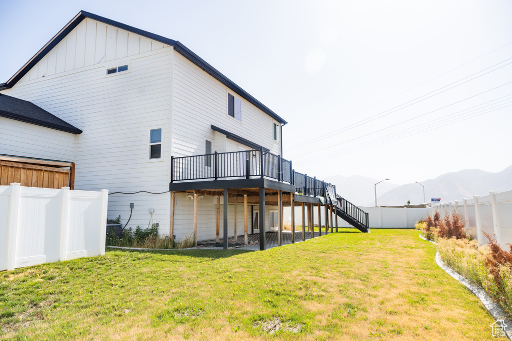 Back of house featuring a deck, a fenced backyard, stairway, and board and batten siding