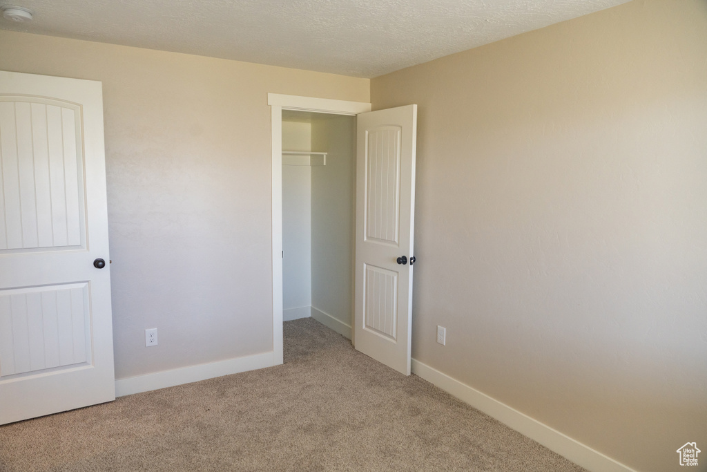 Unfurnished bedroom with carpet and a closet