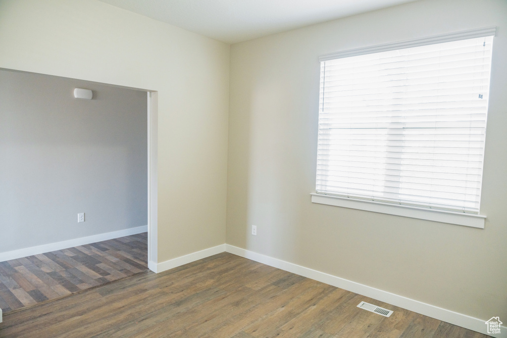 Spare room featuring wood finished floors and healthy amount of natural light