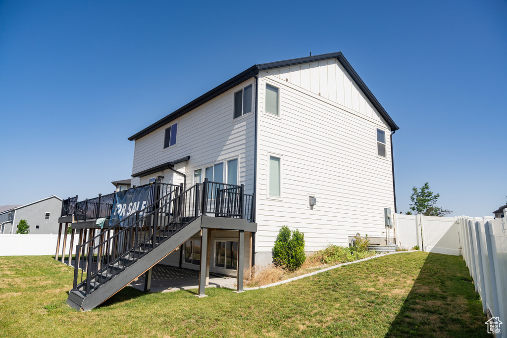 Rear view of property with stairway, a deck, a fenced backyard, and board and batten siding