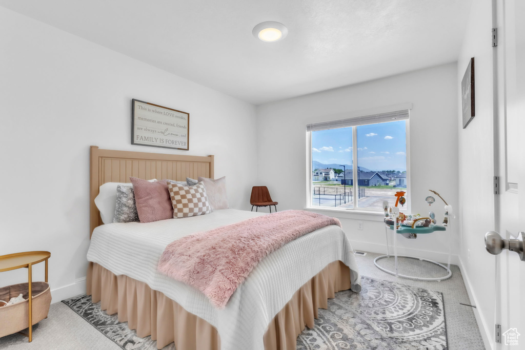 Bedroom featuring baseboards and light carpet