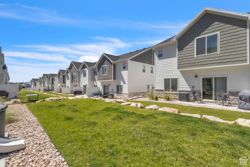 Rear view of house featuring a residential view, a lawn, and a patio area