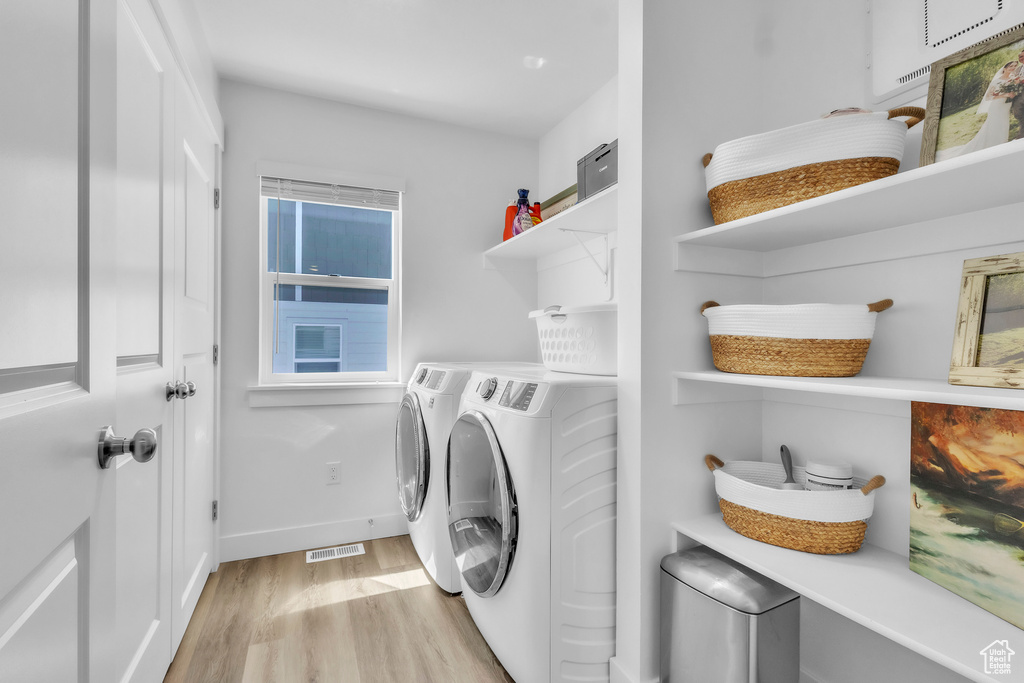 Laundry area featuring washing machine and dryer and light wood finished floors