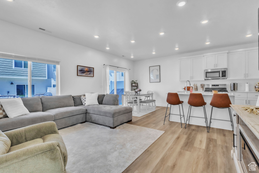 Living area with light wood-style floors and recessed lighting