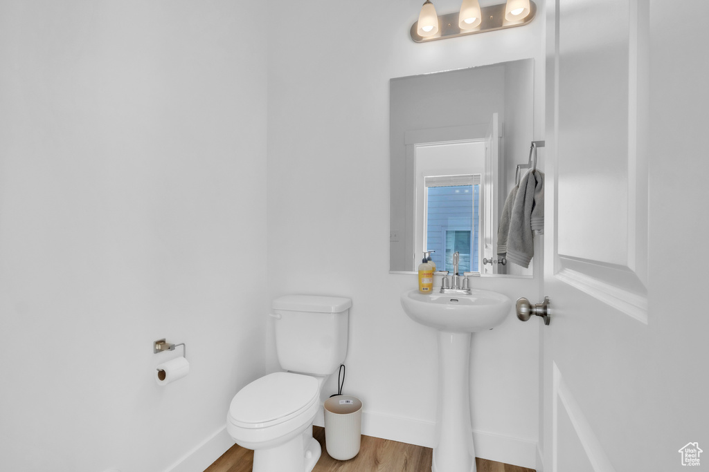 Bathroom with toilet and wood finished floors