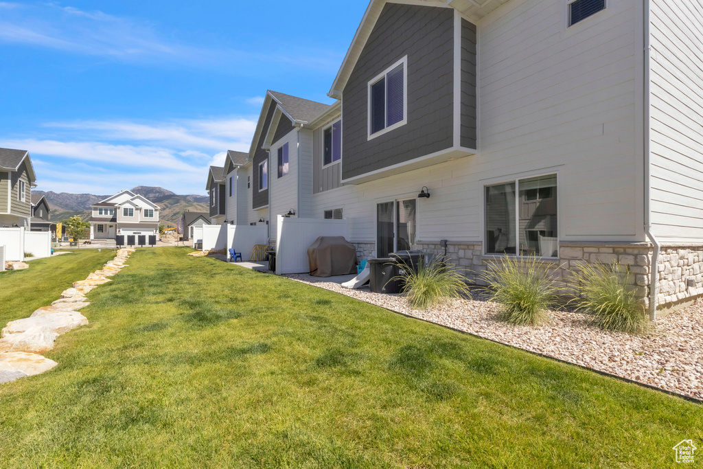 Rear view of property featuring stone siding, a residential view, and a mountain view