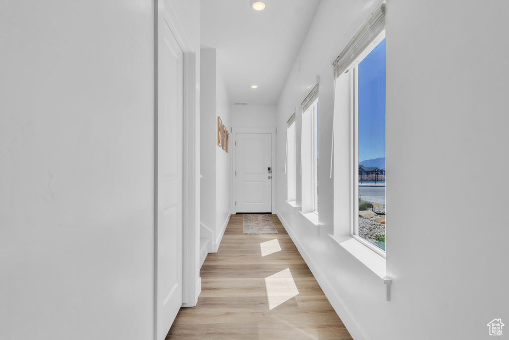 Corridor with plenty of natural light, recessed lighting, and light wood-type flooring