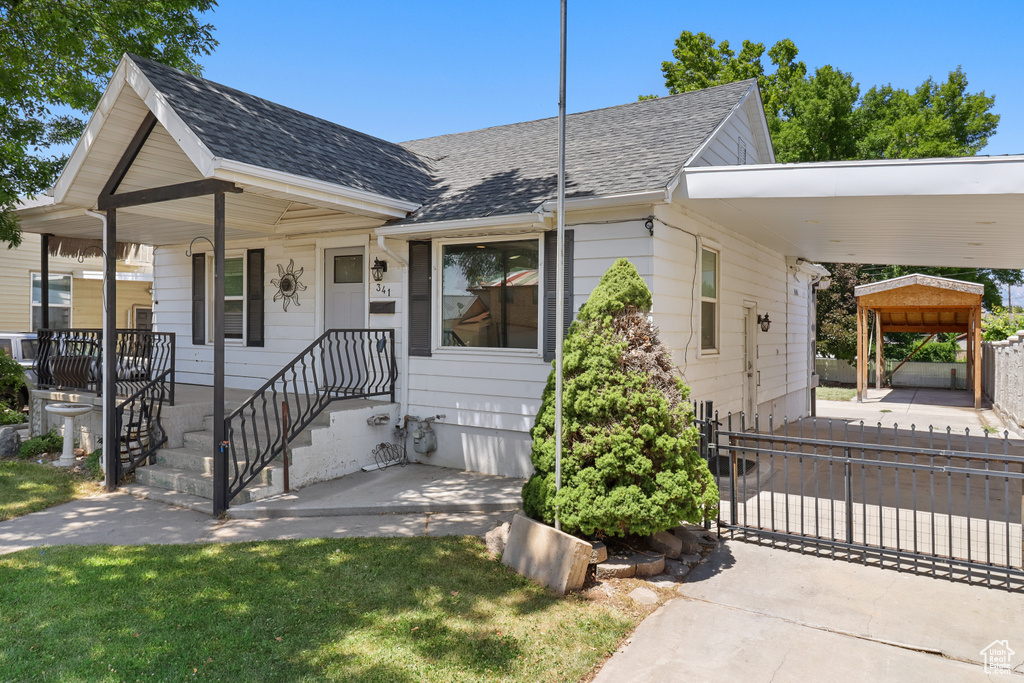 View of front of property with roof with shingles and a gate