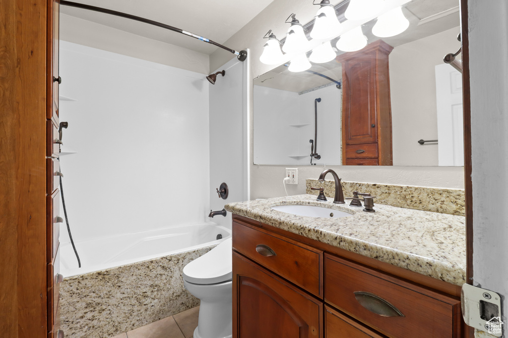 Bathroom featuring vanity, shower / tub combination, and tile patterned flooring