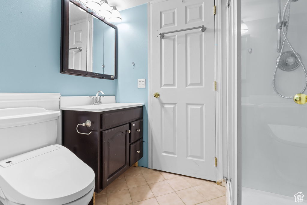 Bathroom featuring vanity, a shower stall, and tile patterned floors