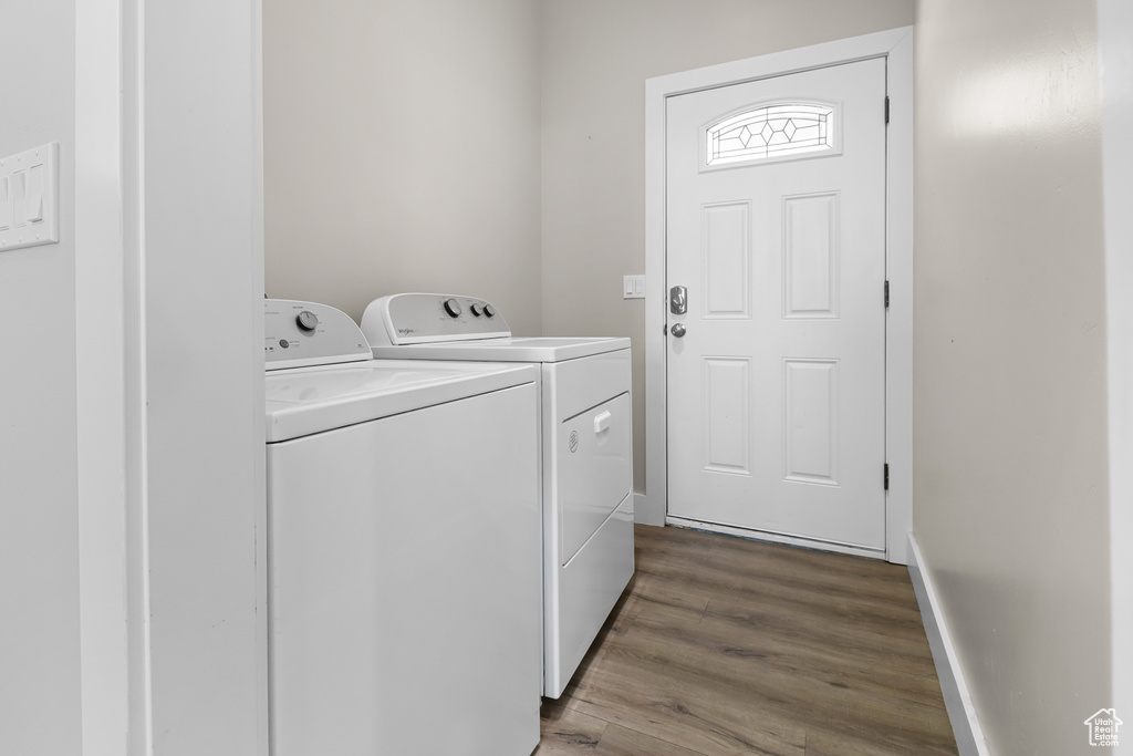 Laundry room with washer and clothes dryer and wood finished floors