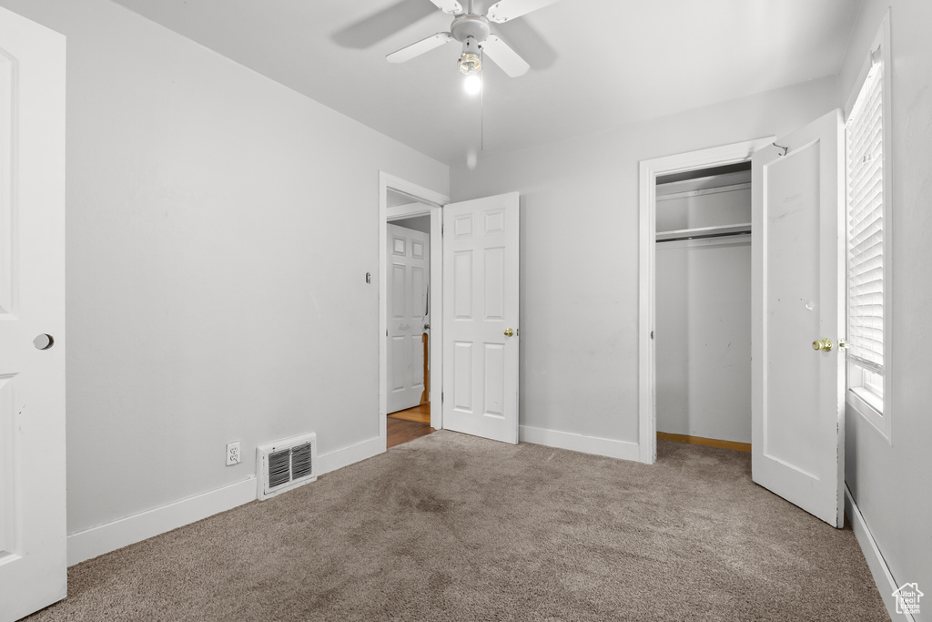 Unfurnished bedroom featuring carpet, a closet, and ceiling fan