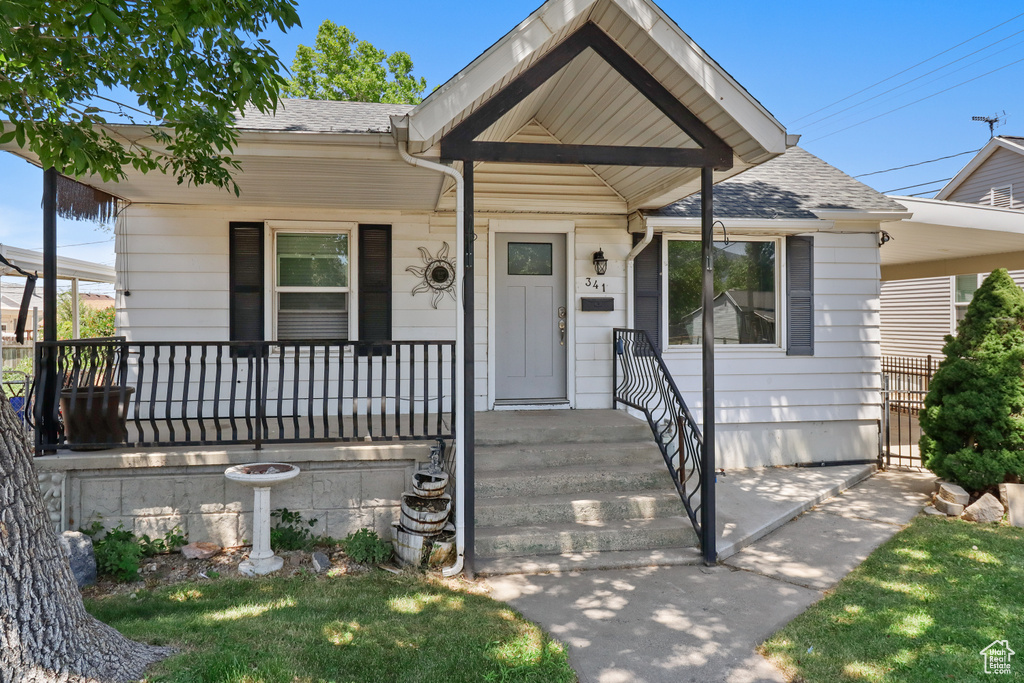 View of front of property featuring roof with shingles and a porch